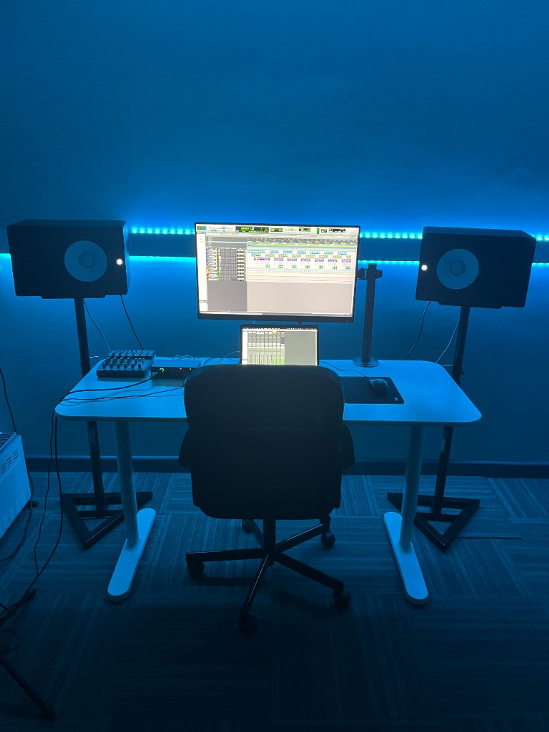 Warrington Music Studio production desk with Yamaha HS monitors, Pro Tools DAW on screen, and blue LED lighting