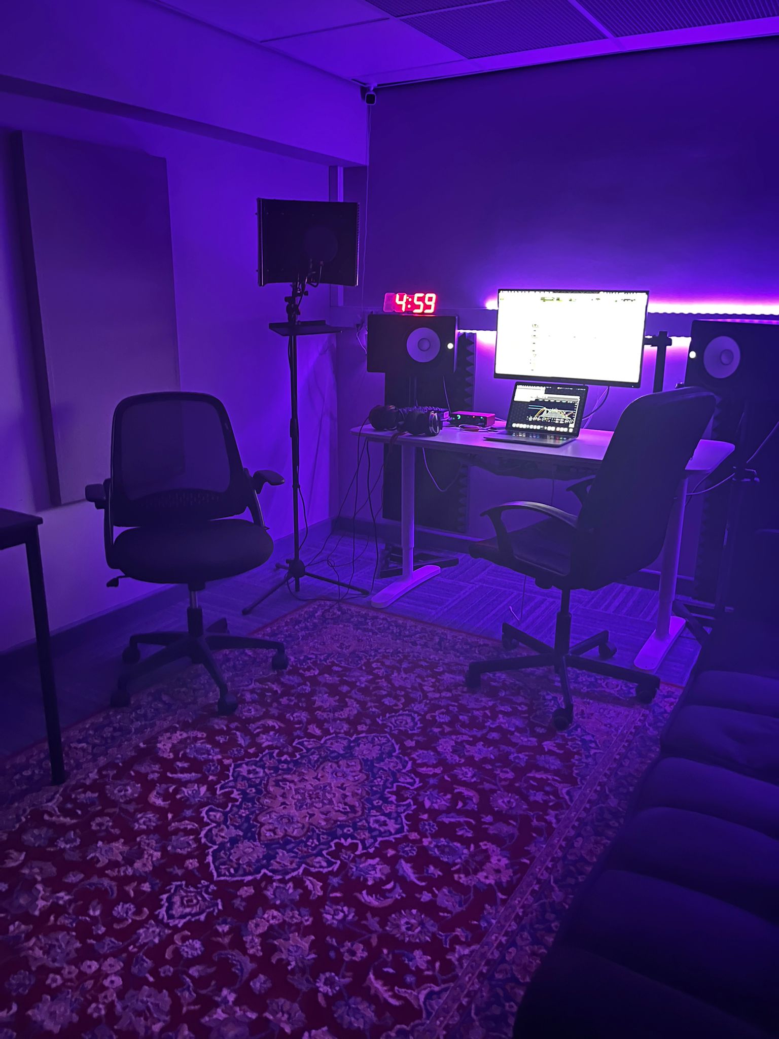 Control room at Evans House lit purple, with the desk, monitors, and chairs