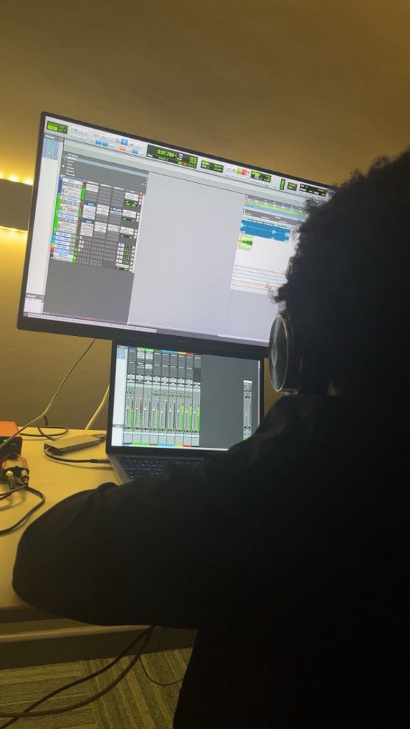 Engineer mixing at Warrington Music Studio with Pro Tools multitrack session, Scarlett headphones, and Yamaha monitoring.