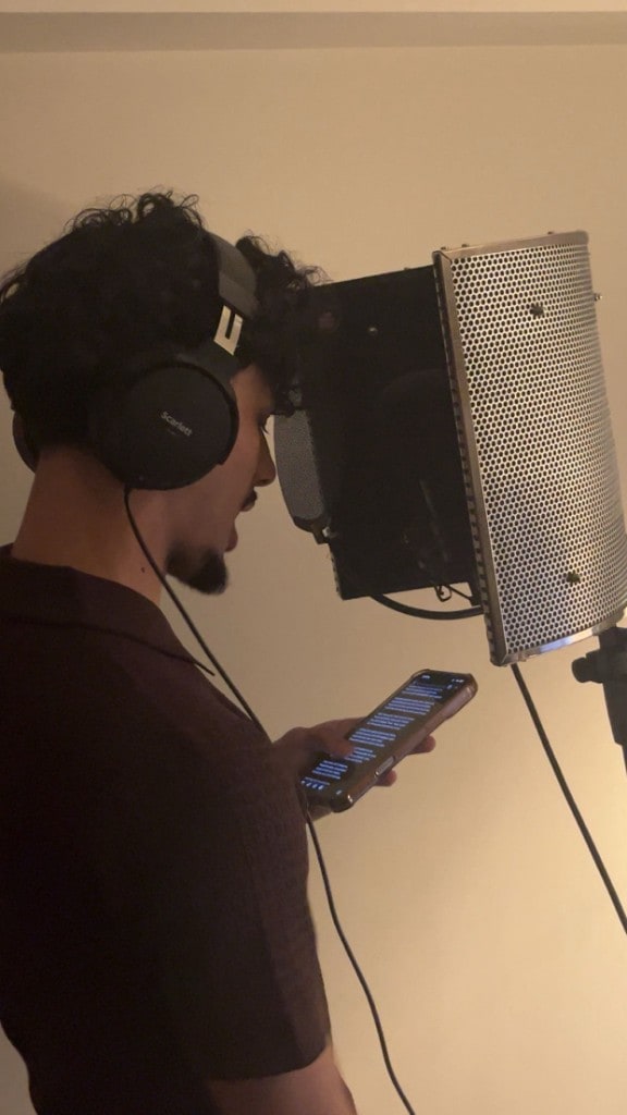 Vocal booth with condenser microphone at Warrington Music Studio in Evans House, Scarlett headphones, and lyrics ready for a take.